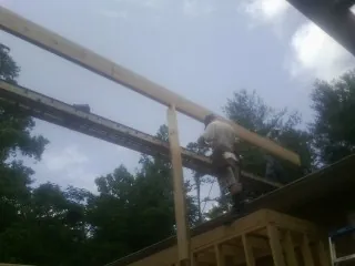 Carpenter setting a ridge beam over a new addition frame — Ice Dam Removal by Roofing Brothers in Industry