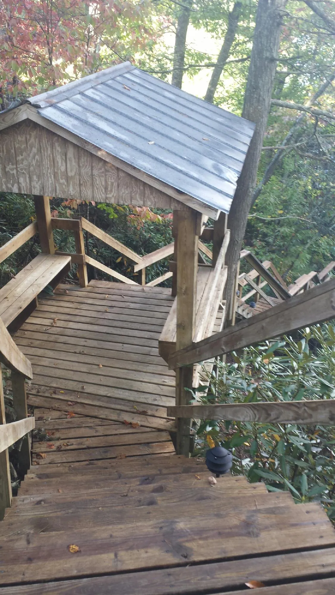 Metal roofed shelter over wooden steps on a wooded walkway — Skylight Repair & Installation work by our crew in Industry