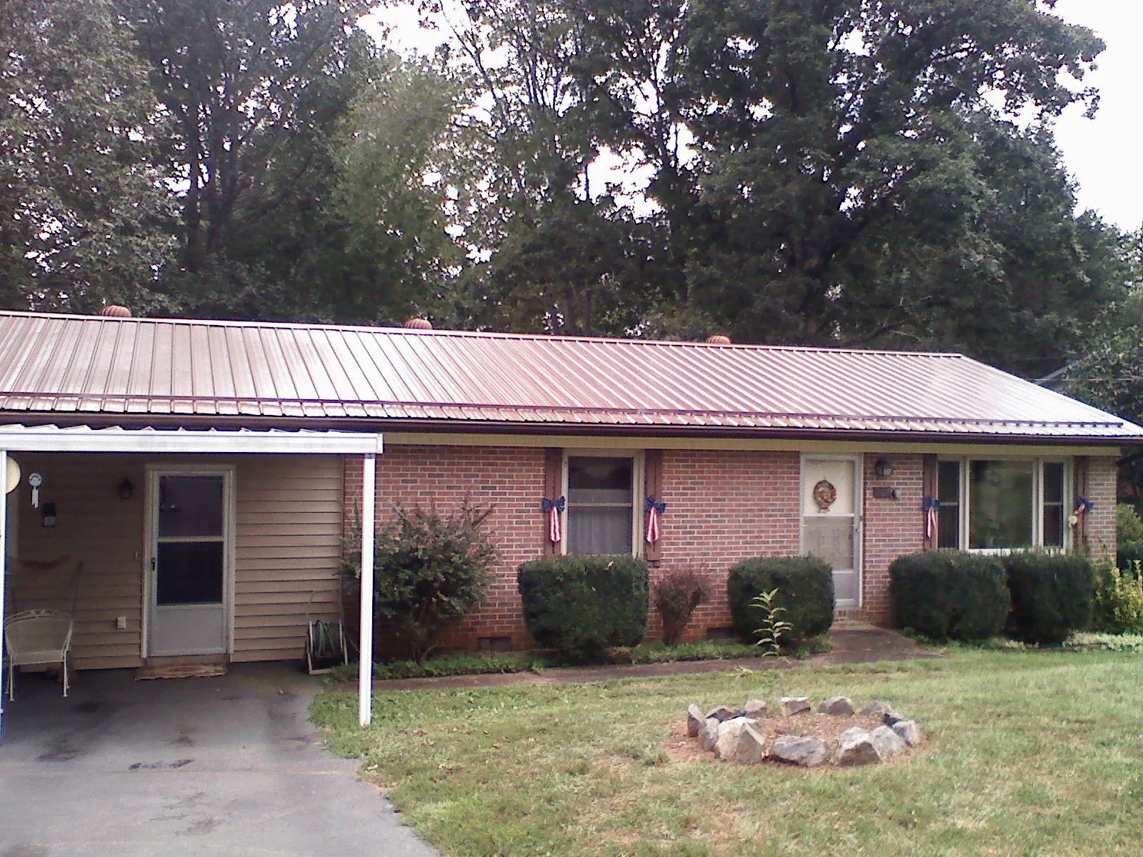 Bronze metal roof and carport on a brick ranch home — Roof Repair work by our crew in Industry